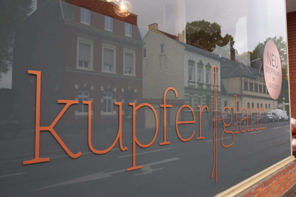 Schriftzug von Friseursalon Kupferglanz in Moenchengladbach auf Schaufenster, Hinweis auf Neueroeffnung
